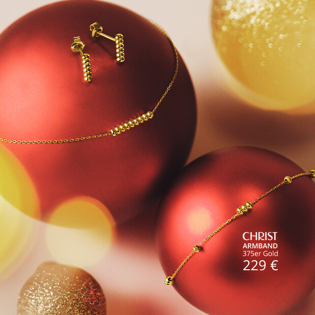 Goldschmuck auf roten Weihnachtskugeln.